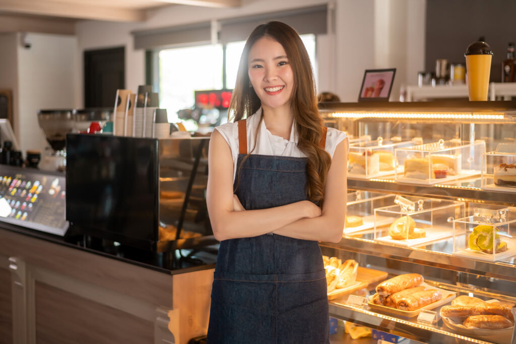 woman standing in front of bakery display