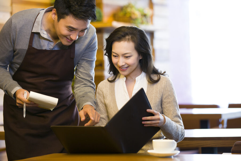 Chinese waiter taking order from woman at restaurant