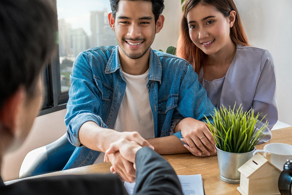 couple handshaking a businessperson